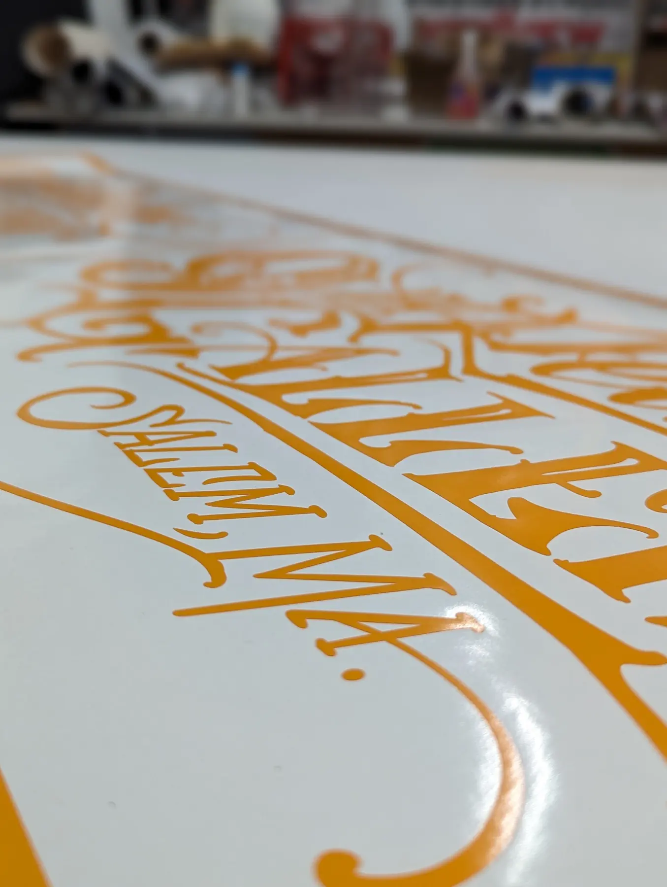 Detalle de letras de vinilo dorado cortado para Shady Deals Gallery antes de la aplicación