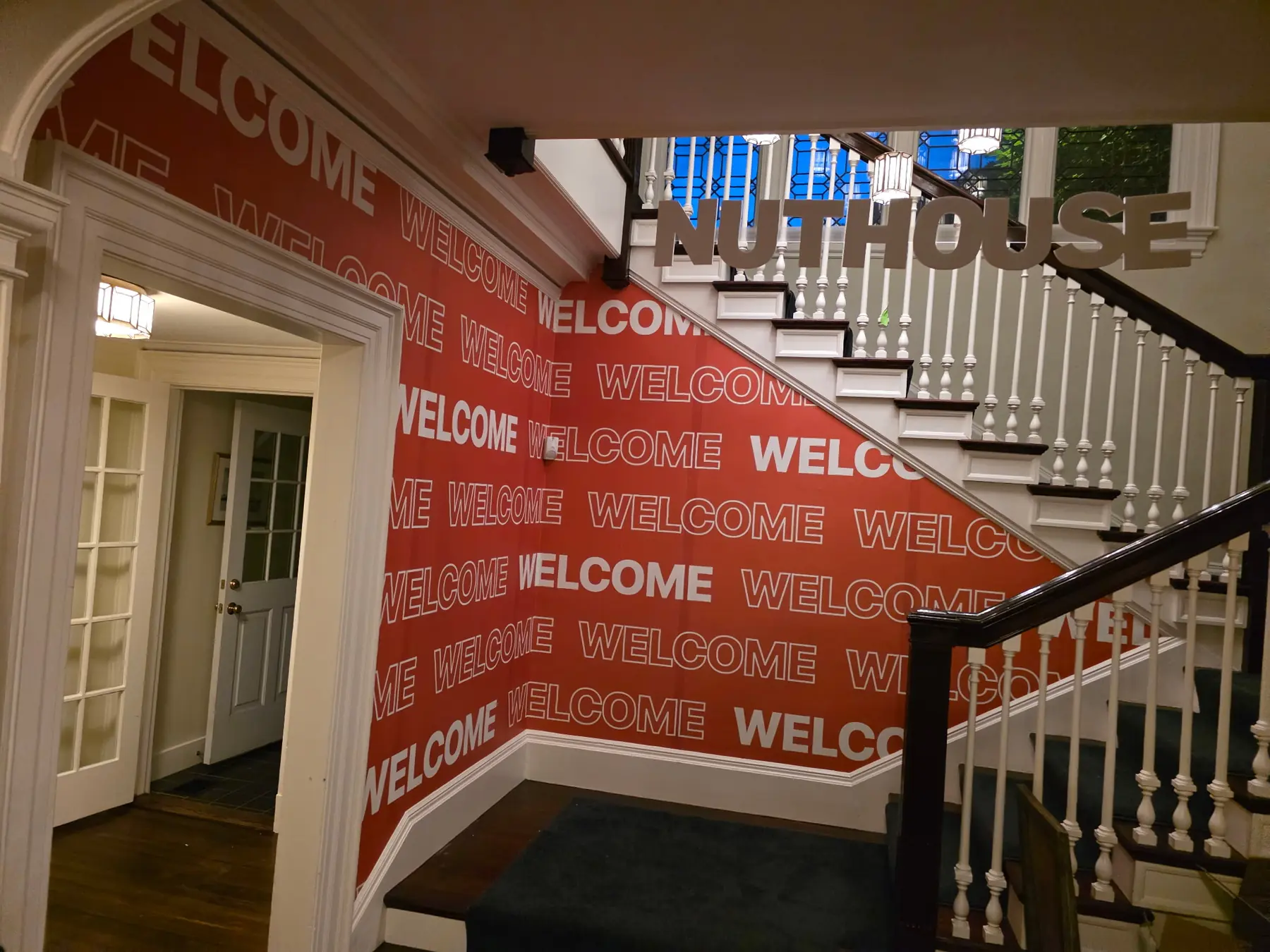 Gráficos de bienvenida de Nuthouse con letras dimensionales suspendidas sobre una escalera